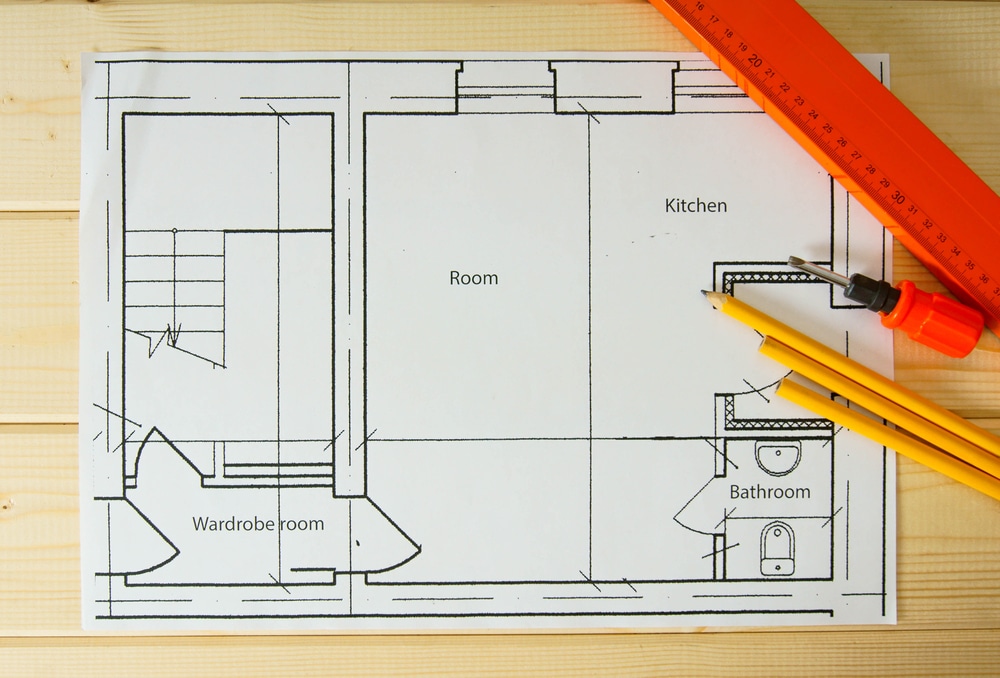 Planning of repair of apartment. Repair work. Drawings for building, helmet, pencils on wooden background.