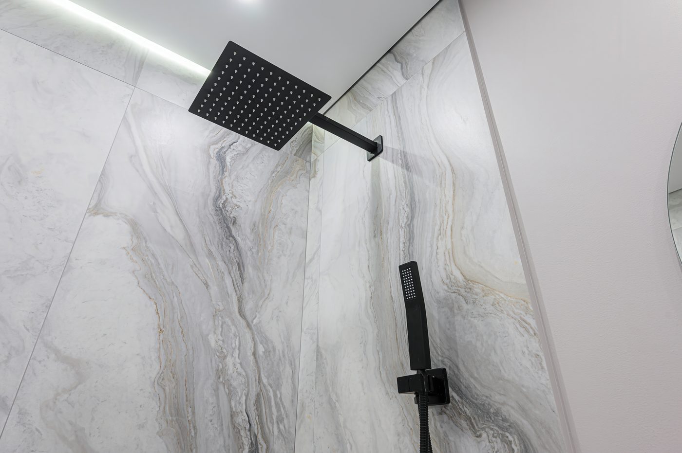 Marble shower with black rainfall and handheld fixtures