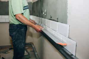 Contractor setting tile during a bathroom remodel