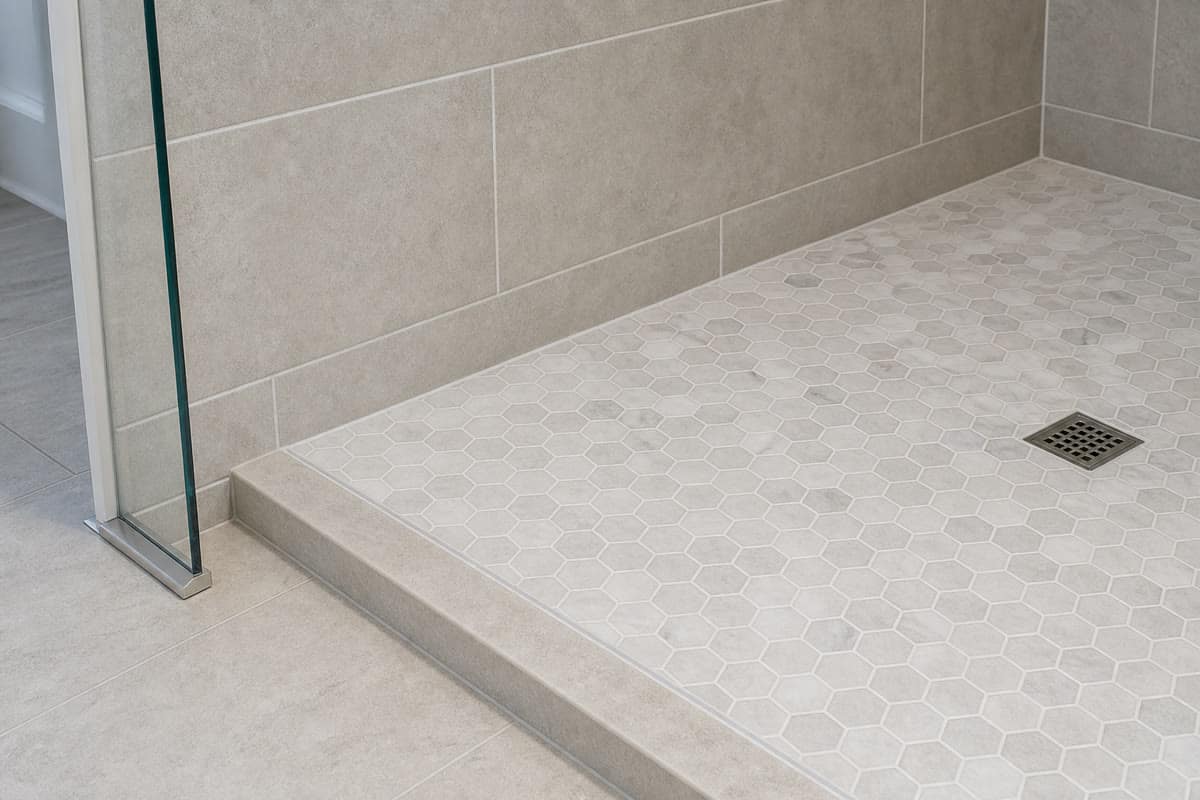 Finished shower corner and floor transition with uniform joints