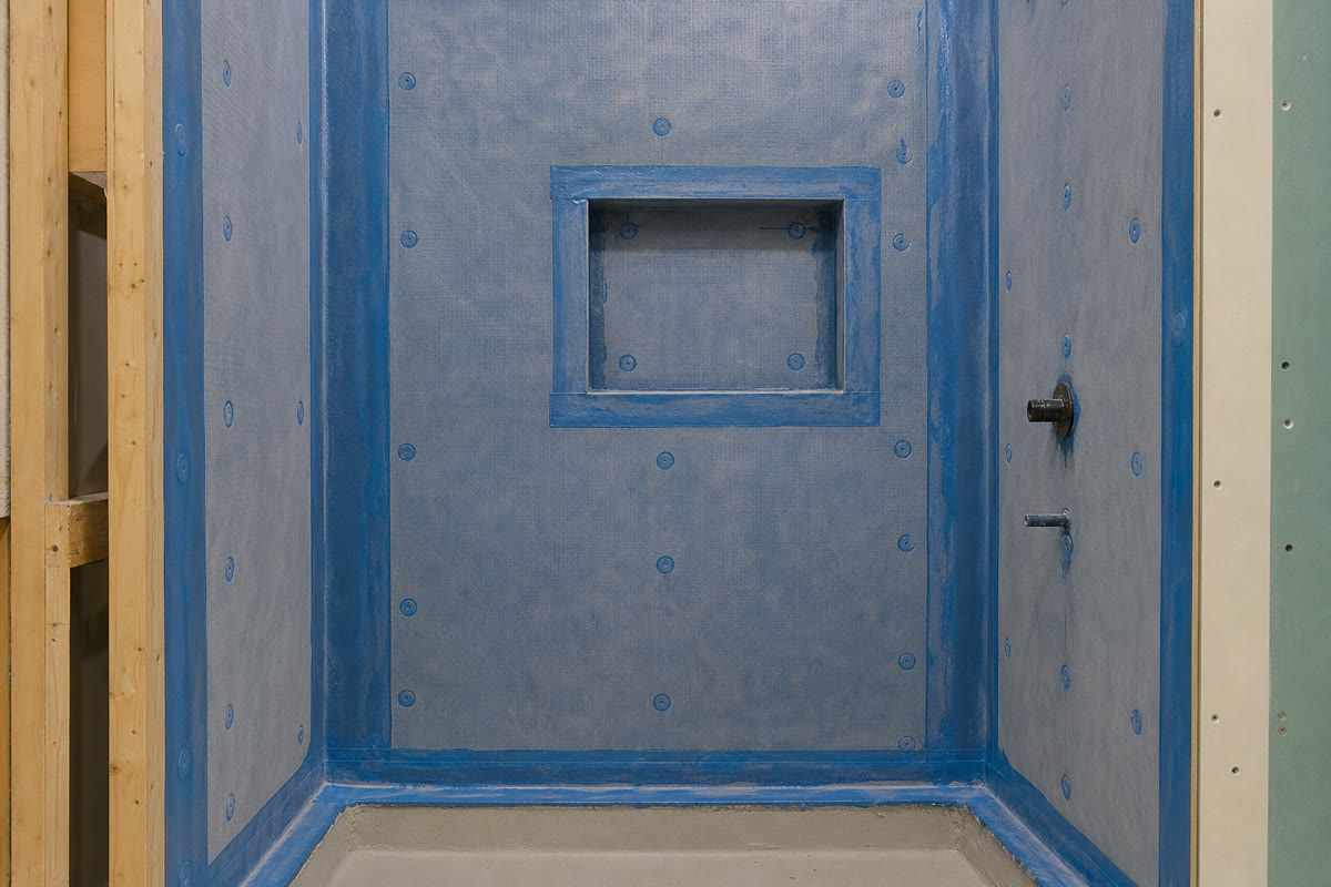Recessed shower niche covered by continuous waterproofing before tile