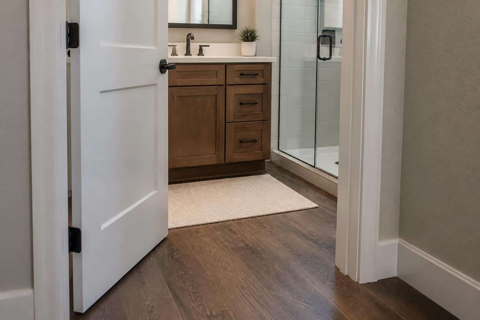 Compact bathroom layout showing door swing arc overlapping a vanity